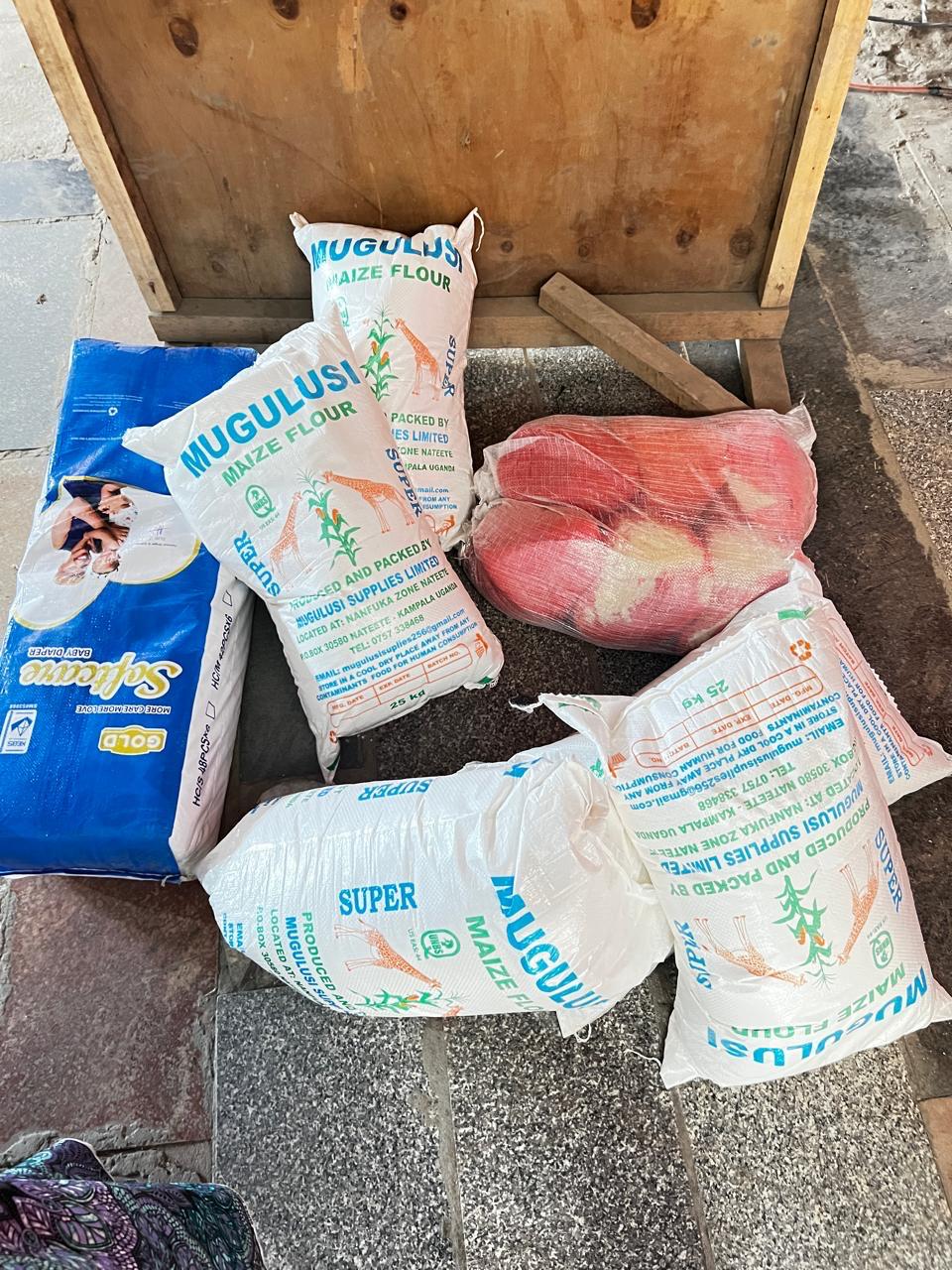 Sebineza Care Organization distributing food supplies and maternal care items to refugee women holding newborn babies in Githurai Kenya.